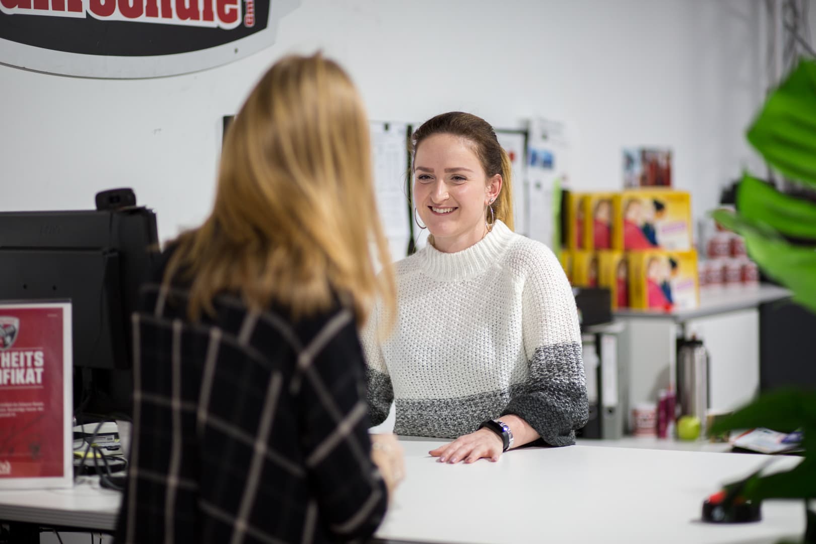 A member of our office team talking with a learner at the front desk